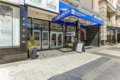 Commercial storefront featuring large display windows and a prominent blue awning - 404 10024 Jasper Avenue, Edmonton, AB 