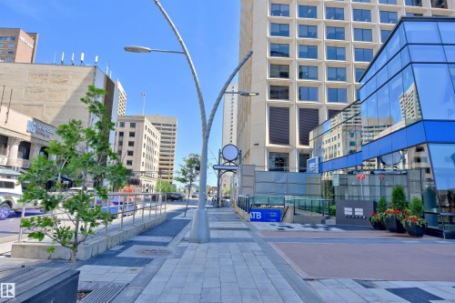 Urban streetscape featuring a modern street lamp and glass-front buildings - 404 10024 Jasper Avenue, Edmonton, AB 