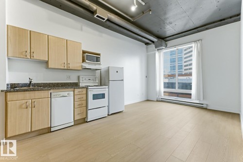 Open-concept living area with light wood-finish flooring - 404 10024 Jasper Avenue, Edmonton, AB 