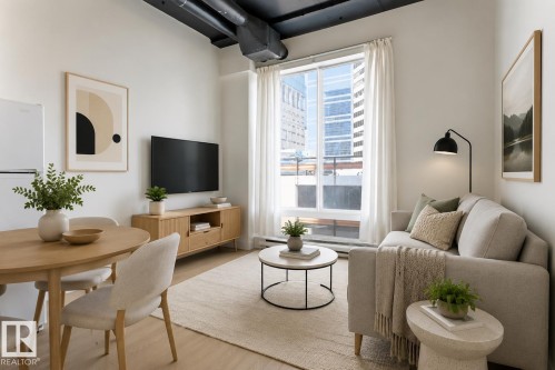 Open-concept living space featuring wood-finish flooring, a large window, and exposed ductwork - 404 10024 Jasper Avenue, Edmonton, AB 