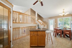 Open-concept living space featuring a central wood-finish island with a dark countertop - 
