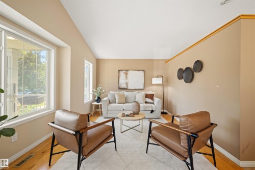 Living area featuring warm neutral wall tones and wood-finish flooring - 7838 Schmid Place Nw, Edmonton, AB 