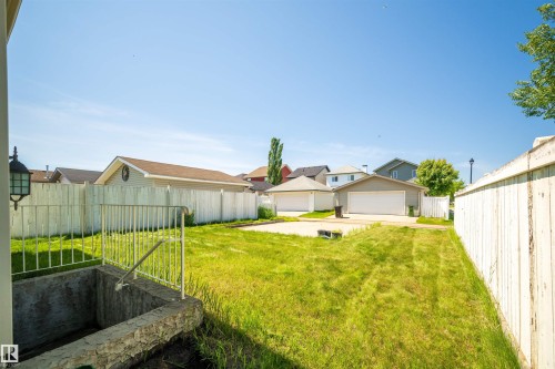 Expansive backyard featuring a mature perimeter fence and a substantial concrete patio pad - 7838 Schmid Place Nw, Edmonton, AB 