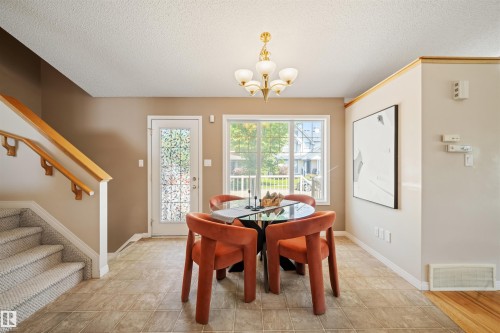 Tiled flooring extending through the dining area with a multi-pane window and glass-paned door - 7838 Schmid Place Nw, Edmonton, AB 