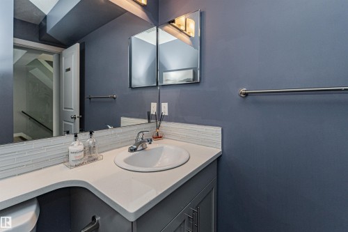 Bathroom featuring a built-in sink, light-toned countertop, and grey base cabinetry with chrome hardware - 35 675 Albany Way, Edmonton, AB 