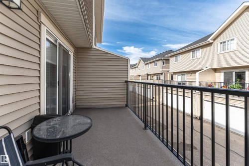 Private balcony with durable flooring, featuring a black metal railing and beige siding exterior - 35 675 Albany Way, Edmonton, AB 