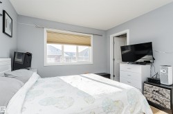 Light-filled room featuring a white window frame, neutral-toned walls, a white paneled door, and a textured window blind - 
