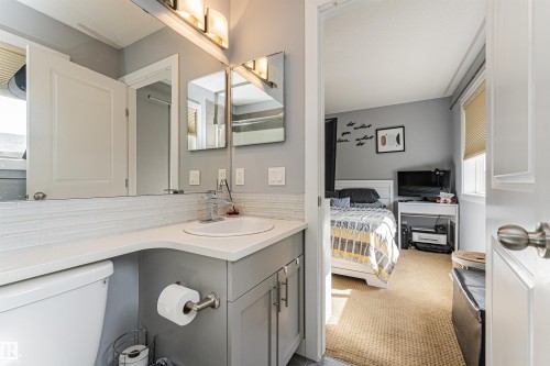 Bathroom vanity featuring a vessel sink, single-handle faucet, and light gray cabinetry - 35 675 Albany Way, Edmonton, AB 