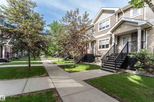 Townhome exterior featuring horizontal siding and stone accents - 35 675 Albany Way, Edmonton, AB 