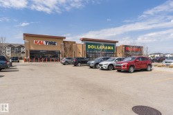 Retail plaza with multiple storefronts featuring large signage and expansive glass facades - 