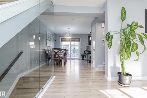 Light wood-finish flooring extending throughout the main level - 35 675 Albany Way, Edmonton, AB 