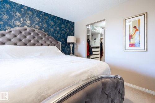 Bedroom featuring a bold floral accent wall and neutral wall tones - 330 1520 Hammond Gate Gate, Edmonton, AB 