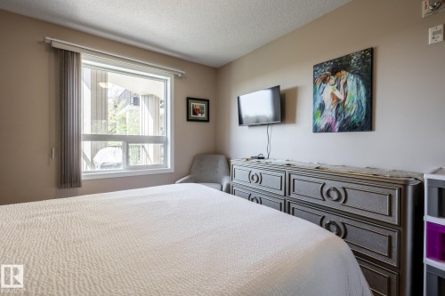 Spacious room featuring a large window with vertical blinds, light neutral wall paint, and textured ceiling - 330 1520 Hammond Gate Gate, Edmonton, AB 
