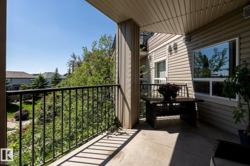 Private balcony featuring a concrete floor, black metal railing, and a beige vinyl siding exterior wall - 330 1520 Hammond Gate Gate, Edmonton, AB 