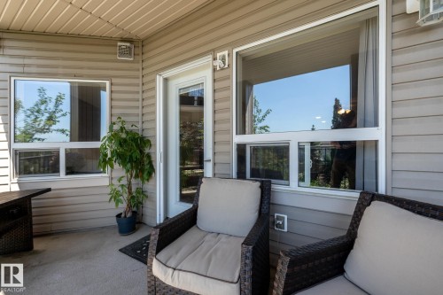 Patio area featuring light-toned vinyl siding and a textured concrete surface - 330 1520 Hammond Gate Gate, Edmonton, AB 