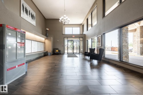 Spacious lobby featuring wood-finish tile flooring, large floor-to-ceiling windows, and recessed lighting - 330 1520 Hammond Gate Gate, Edmonton, AB 