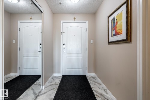 Foyer featuring marble-look tile flooring and light-toned walls - 330 1520 Hammond Gate Gate, Edmonton, AB 