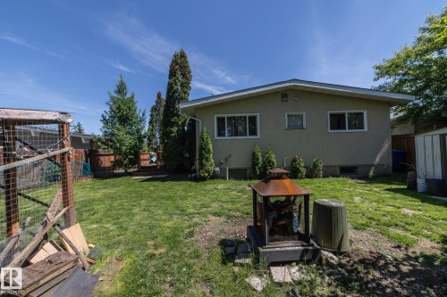 Expansive backyard featuring a manicured lawn, established perimeter trees, wood privacy fencing, and a stucco exterior - 3608 44 Street, Leduc, AB 