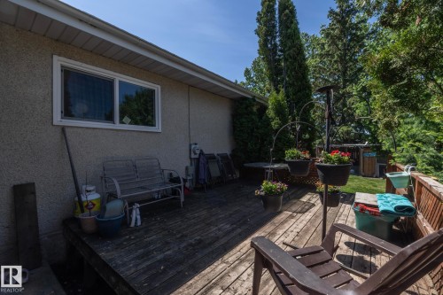 Spacious wood-plank deck offering an outdoor extension of the home, surrounded by mature trees - 3608 44 Street, Leduc, AB 