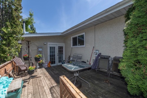 Expansive wood deck with a privacy fence, dual French doors, and stucco exterior - 3608 44 Street, Leduc, AB 