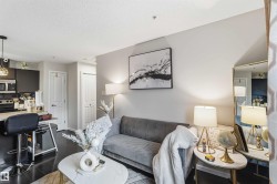 Open-concept living area featuring dark wood-finish flooring, light grey walls, and recessed lighting - 
