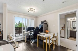 Open concept living space featuring wood-finish flooring, a contemporary ceiling light fixture, and a sliding glass door leading to an outdoor balcony - 