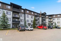 Multi-story condominium building featuring light grey siding with dark brown accents and multiple balconies - 