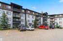 Multi-story condominium building featuring light grey siding with dark brown accents and multiple balconies - 244 1196 Hyndman Road, Edmonton, AB 