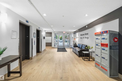 Building entry features light wood-finish flooring, recessed lighting, and a modern color palette - 244 1196 Hyndman Road, Edmonton, AB 