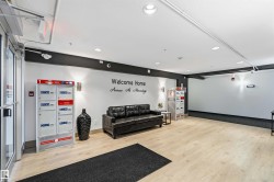 Spacious entryway featuring light wood-finish flooring, recessed lighting, wall sconces, and a dark accent wall - 