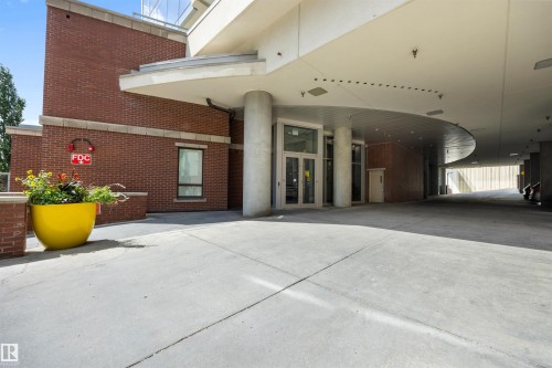 Building entrance featuring brick facade and a wide concrete approach - 802 9720 106 Street, Edmonton, AB 