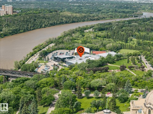 Aerial perspective showcasing the river valley, lush green spaces, extensive tree coverage, and a distant bridge structure - 802 9720 106 Street, Edmonton, AB 