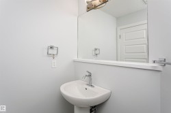 Pedestal sink with chrome faucet, large vanity mirror, and brushed nickel light fixture - 