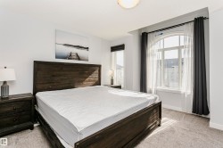 Bedroom featuring an arched window, a second window, and carpet flooring - 