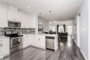 Modern kitchen featuring white cabinetry, stainless steel appliances, a mosaic tile backsplash, and light-toned countertops - #55 723 172 St Sw, Edmonton, AB  - Indoor Photo Showing Kitchen With Upgraded Kitchen 