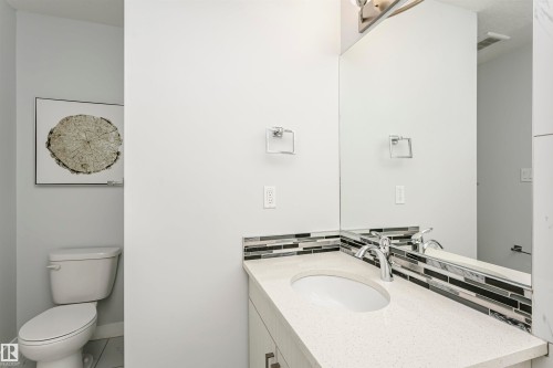 Vanity with a light-toned countertop, integrated sink, and chrome faucet - #55 723 172 St Sw, Edmonton, AB - Indoor Photo Showing Bathroom