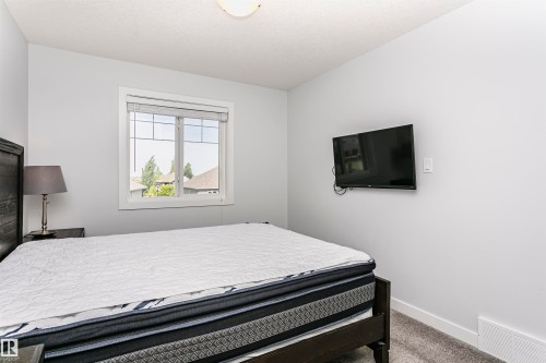 Bright room with a large window, soft gray walls, and plush gray carpeting - #55 723 172 St Sw, Edmonton, AB - Indoor Photo Showing Bedroom