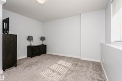 Carpeted room with a ceiling-mounted light fixture and a window featuring horizontal blinds - 