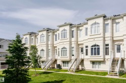 Row of multi-story townhomes featuring light-toned exteriors with decorative architectural accents - 