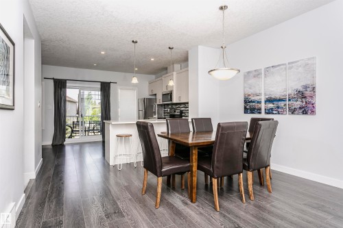 Dining area featuring wood-finish flooring, a contemporary pendant light fixture, and an open concept layout - #55 723 172 St Sw, Edmonton, AB - Indoor Photo Showing Dining Room