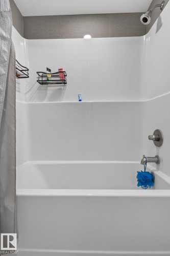White bathtub and shower combination featuring a brushed nickel showerhead and faucet - 1504 9720 106 Street, Edmonton, AB 
