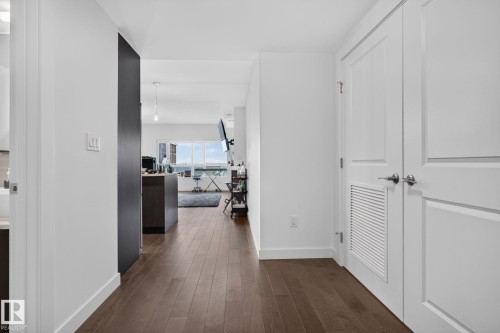 Hallway featuring wood-finish flooring, crisp white walls, and bright white trim - 1504 9720 106 Street, Edmonton, AB 