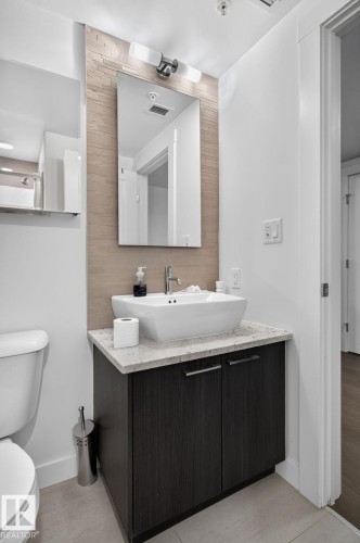 Bathroom featuring a rectangular vessel sink, light-toned stone countertop, and dark wood-finish vanity with chrome hardware - 1504 9720 106 Street, Edmonton, AB 