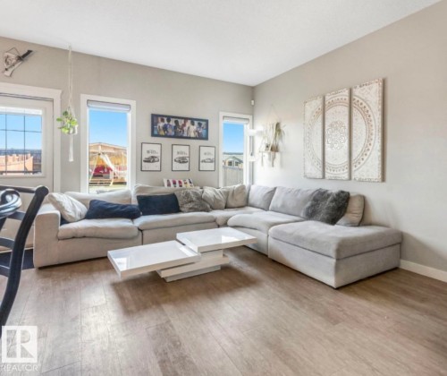 Spacious living area featuring light-toned walls and wood-finish flooring - 17171 38 Street, Edmonton, AB 