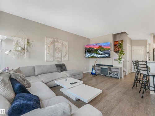 Spacious living area featuring light gray walls, wood-finish flooring, and recessed lighting - 17171 38 Street, Edmonton, AB 