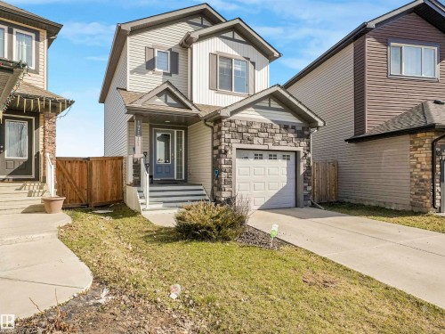 Two-story residence featuring light-colored siding and a stone-clad garage - 17171 38 Street, Edmonton, AB 