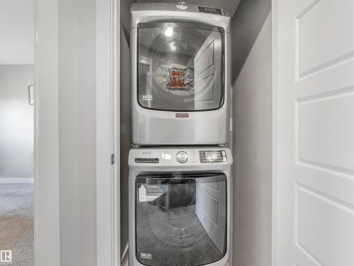 Compact laundry closet featuring a stacked washer and dryer unit - 17171 38 Street, Edmonton, AB 