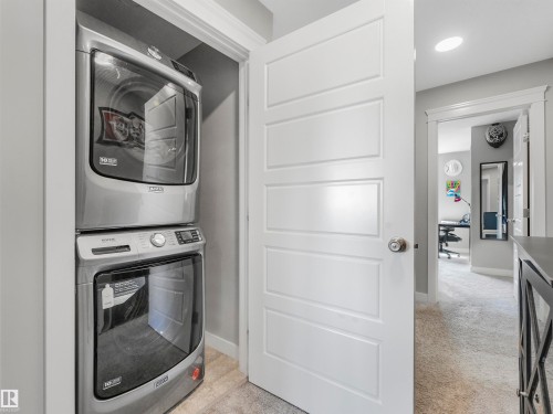 Dedicated laundry closet featuring a stacked washer and dryer unit - 17171 38 Street, Edmonton, AB 