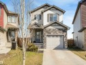 Contemporary two-story home featuring a stone veneer facade, a single-car garage with a panel door, and an arched entry porch - 17171 38 Street, Edmonton, AB 