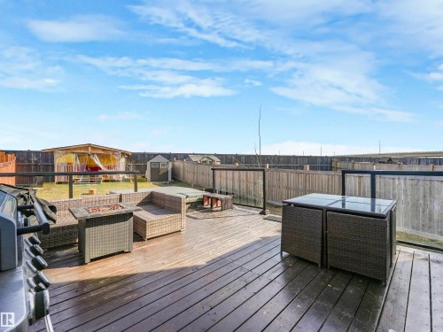 Spacious wood-finish deck with glass panel railing and a privacy fence - 17171 38 Street, Edmonton, AB 